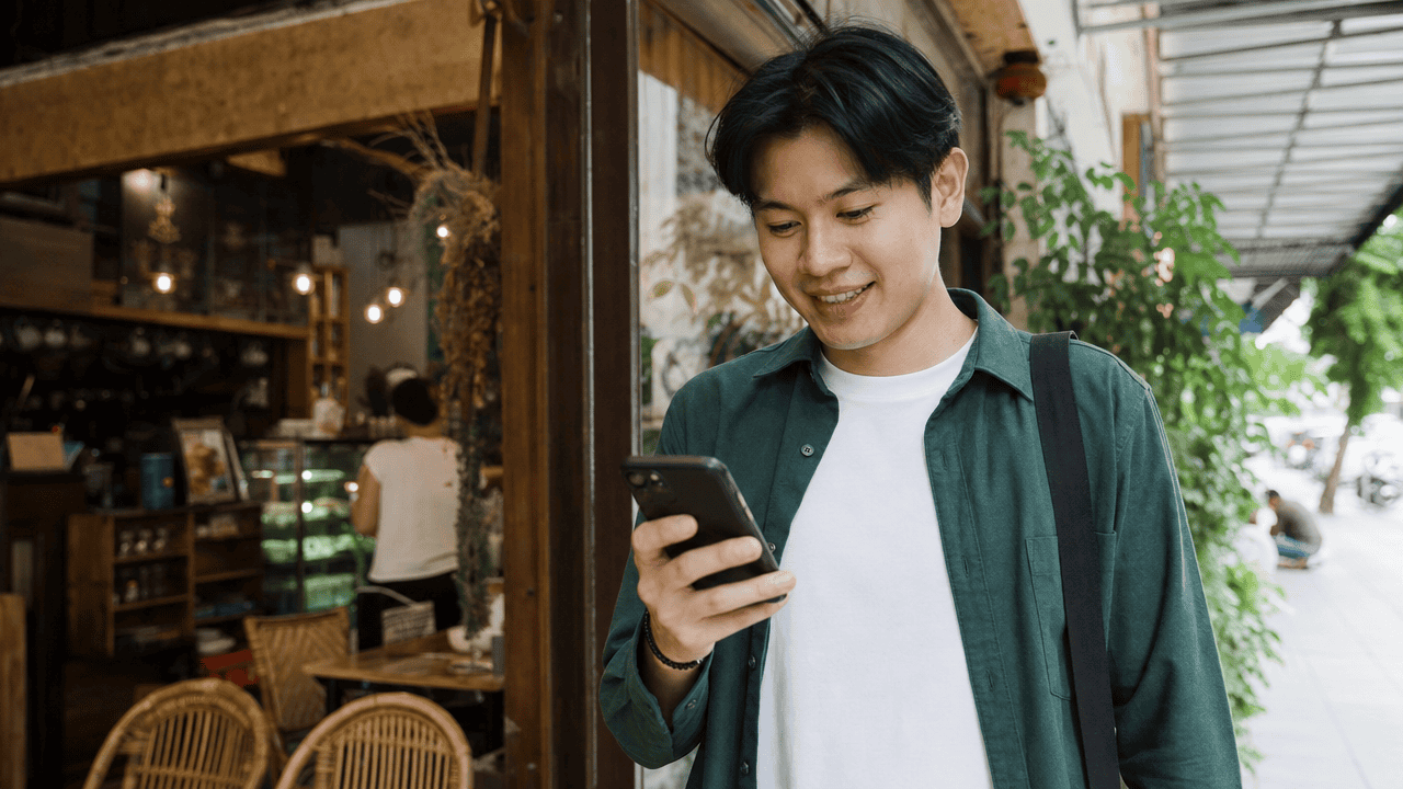 SEO Friendly คืออะไร? คู่มือทำเว็บให้ SEO Friendly 2026 4 คนถือมือถือในร้านกาแฟระหว่างทำเว็บให้ seo friendly