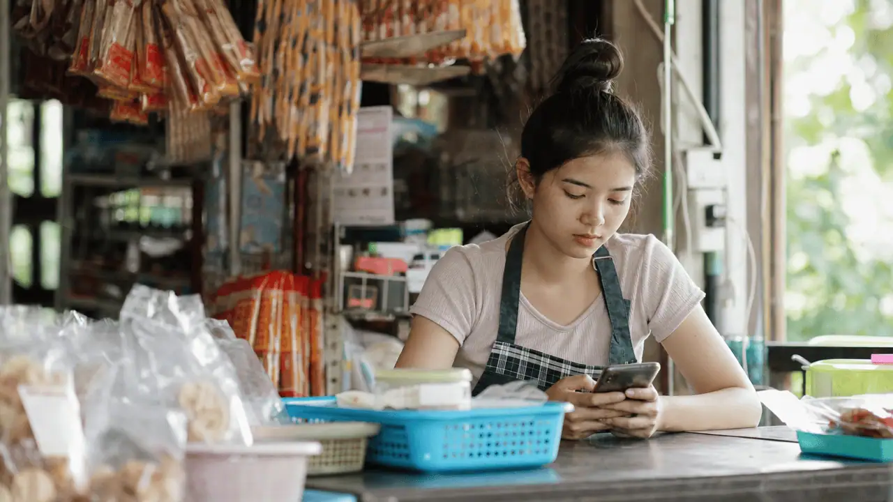 ตัวจัดการเพจ Facebook คืออะไร ใช้งานยังไง 2026 4 พนักงานใช้แอปจัดการเพจ facebook ในมือถือตอบลูกค้า