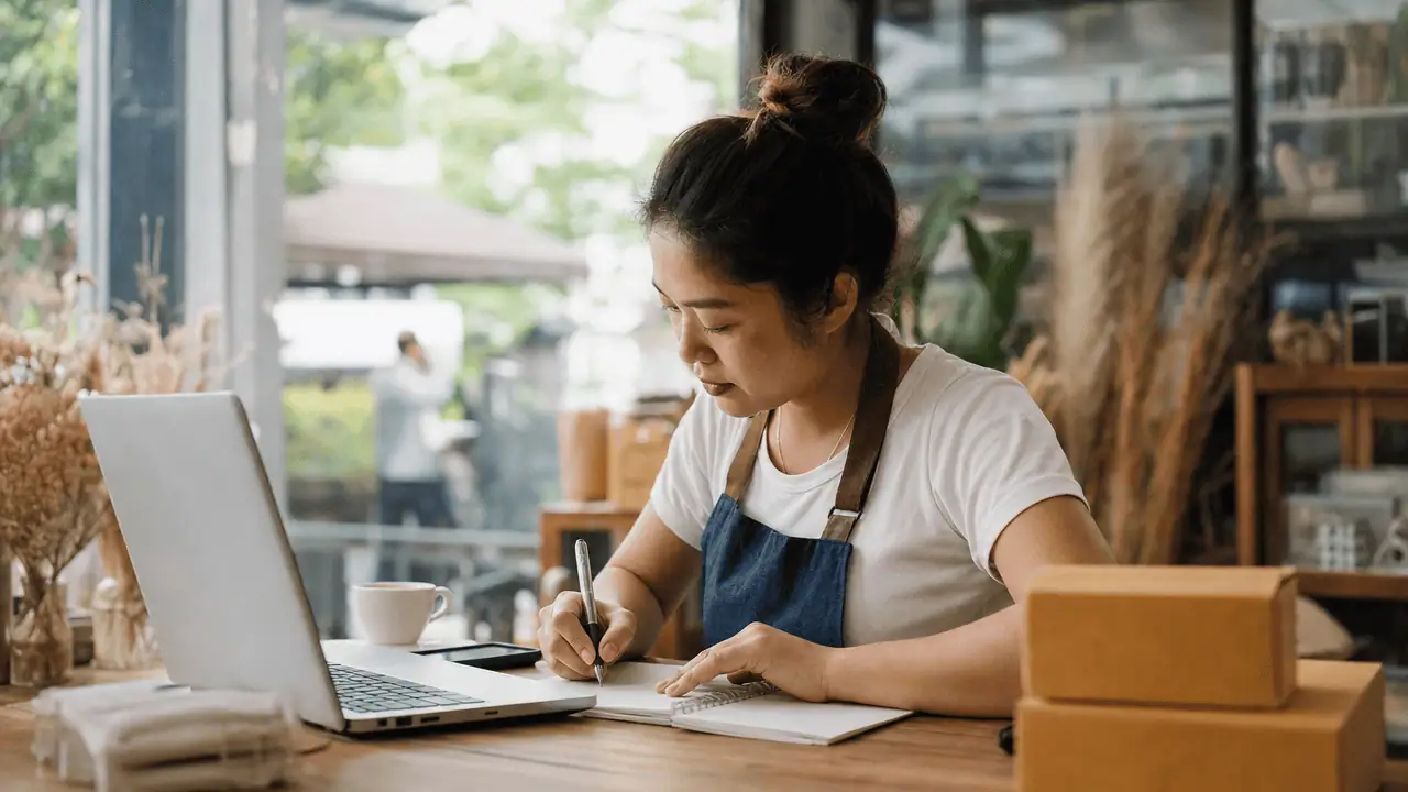 Google Ads Keyword Planner คืออะไร ใช้ยังไง 2026 4 เจ้าของร้านจดรายการคีย์เวิร์ดฟรีจาก keyword planner ลงสมุดโน้ตเพื่อวางแผนคอนเทนต์